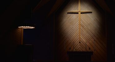 brown wooden cross on brown wooden wall